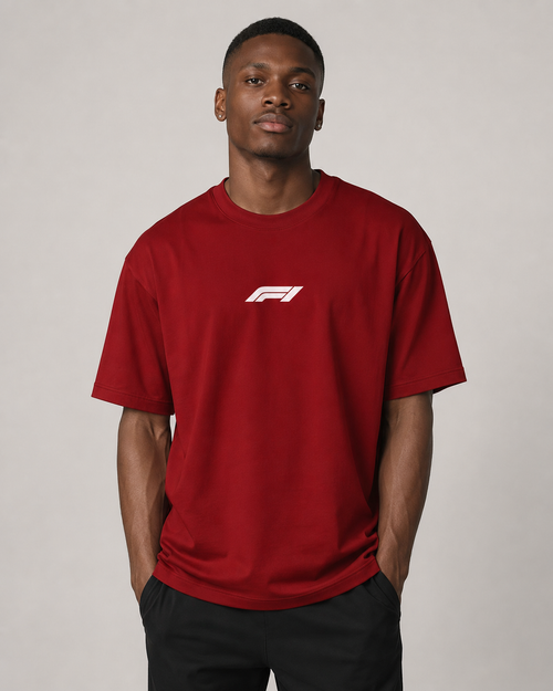 Man wearing a red t-shirt with a logo on a plain background