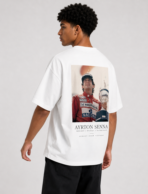 Person wearing a white t-shirt with Ayrton Senna graphic on a plain background