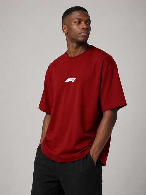 Man wearing a red t-shirt with a logo on a gray background