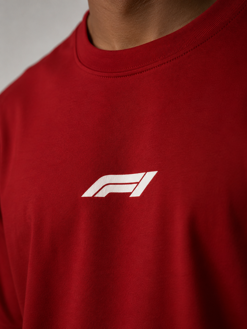 Red t-shirt with a white logo on a neutral background